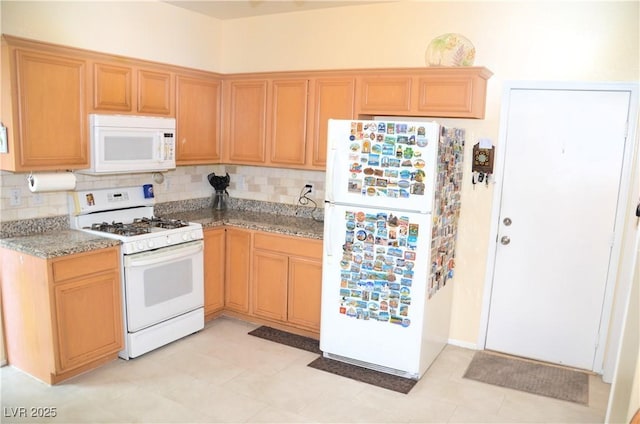 kitchen with light stone counters, backsplash, and white appliances