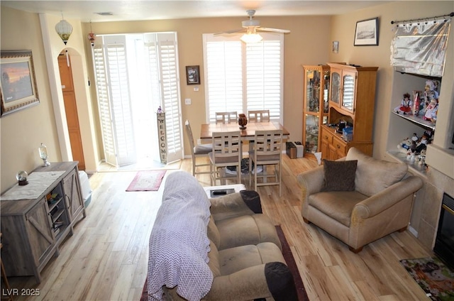 living room with ceiling fan and light hardwood / wood-style flooring