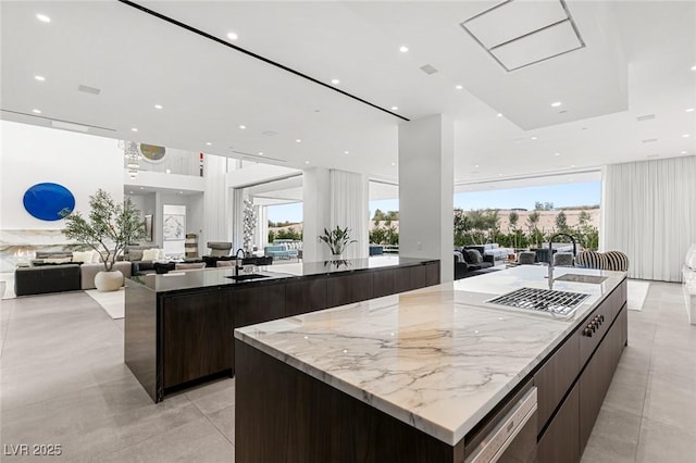 kitchen featuring a large island with sink, dishwasher, and sink