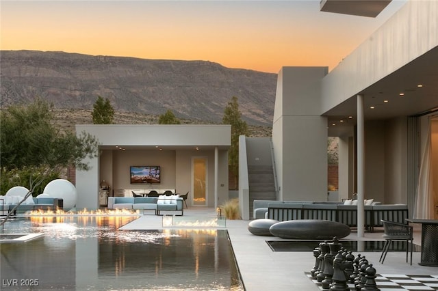 back house at dusk featuring an outdoor hangout area and a patio