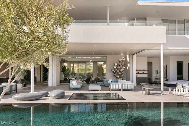 rear view of house with a swimming pool with hot tub, a patio area, and outdoor lounge area