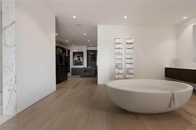 bathroom featuring hardwood / wood-style flooring, vanity, and a tub