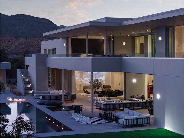 back house at dusk with a mountain view and an outdoor hangout area