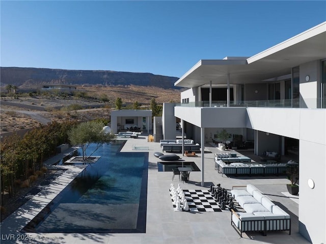 view of swimming pool featuring a patio, a mountain view, and an outdoor hangout area