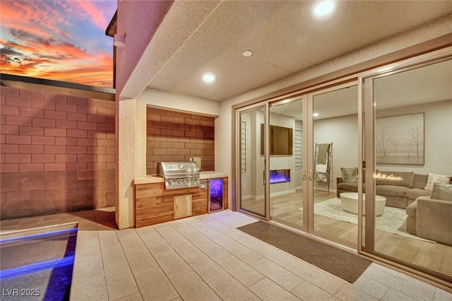 patio terrace at dusk with area for grilling and a grill