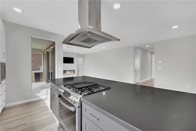 kitchen with white cabinetry, appliances with stainless steel finishes, and island exhaust hood