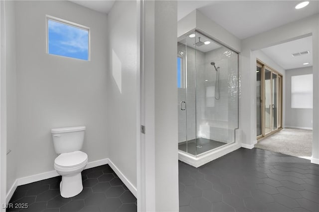 bathroom featuring toilet, an enclosed shower, and tile patterned flooring