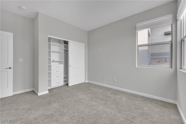 unfurnished bedroom featuring light colored carpet and a closet