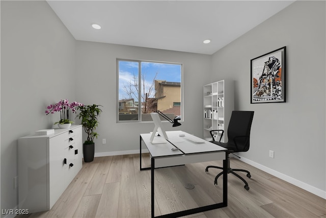 home office with light hardwood / wood-style flooring