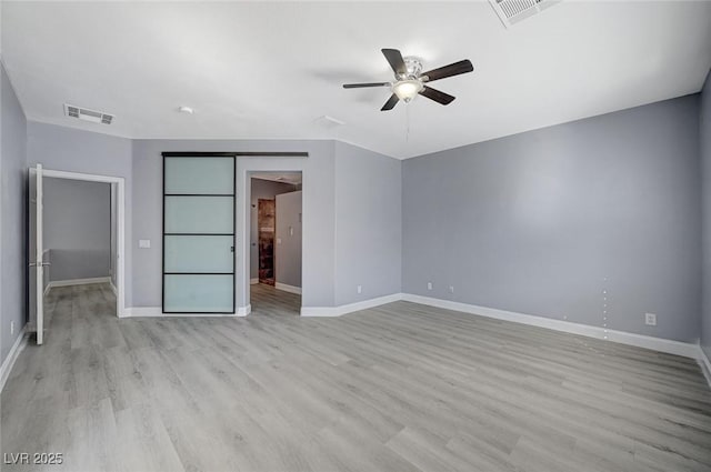 unfurnished bedroom featuring baseboards, a ceiling fan, visible vents, and light wood-style floors