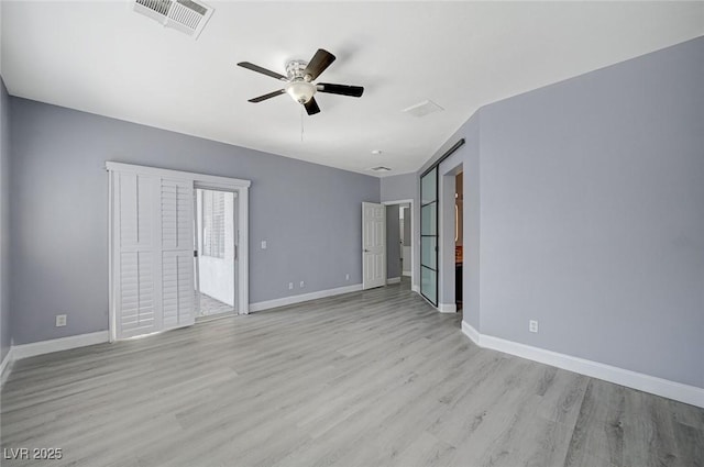 spare room featuring ceiling fan, light wood-style floors, visible vents, and baseboards