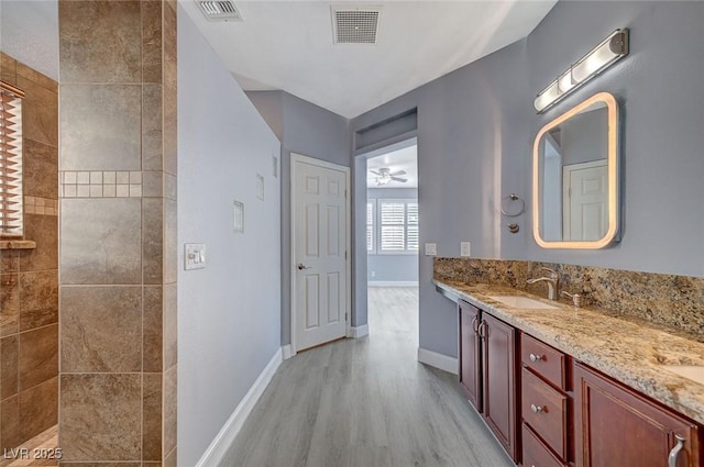 bathroom with a walk in shower, visible vents, a sink, and wood finished floors