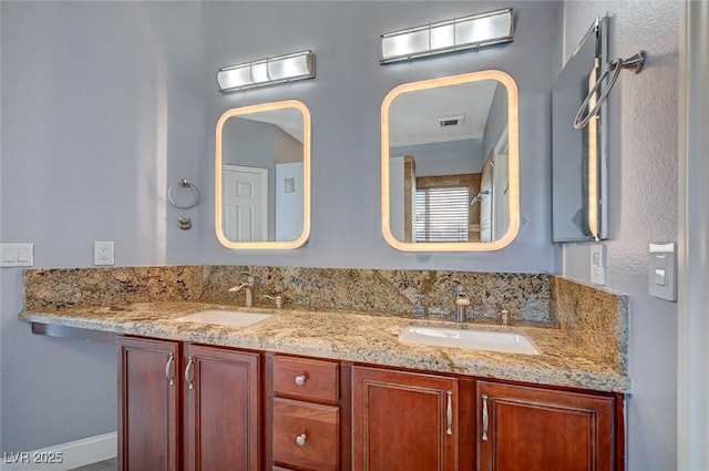 bathroom with double vanity, a sink, and visible vents