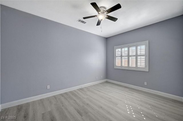 unfurnished room with visible vents, ceiling fan, baseboards, and wood finished floors