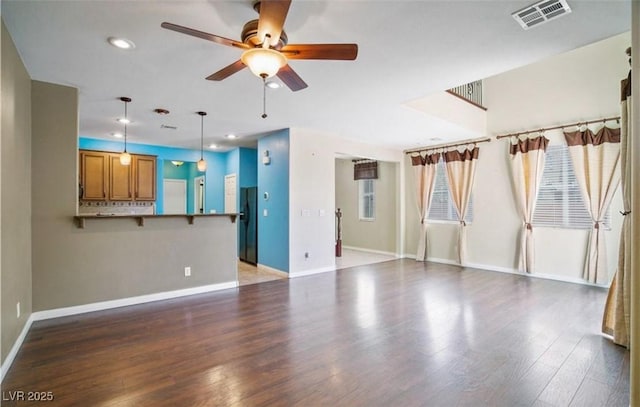 unfurnished living room with dark wood-type flooring and ceiling fan