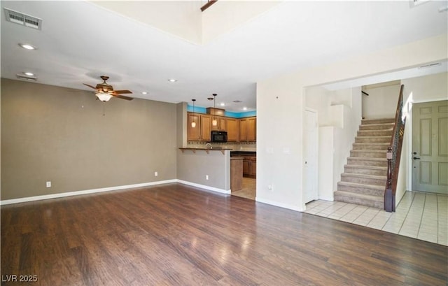 unfurnished living room with ceiling fan and light wood-type flooring