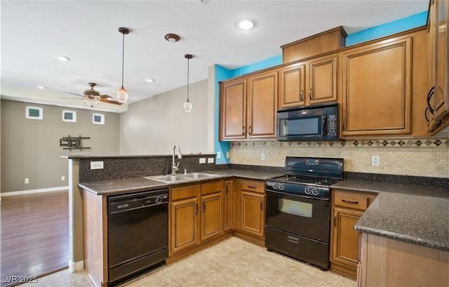 kitchen with sink, ceiling fan, hanging light fixtures, black appliances, and decorative backsplash