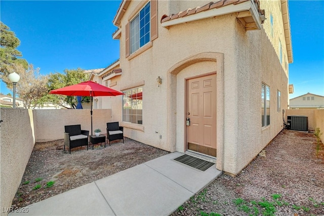 property entrance with central AC unit and a patio