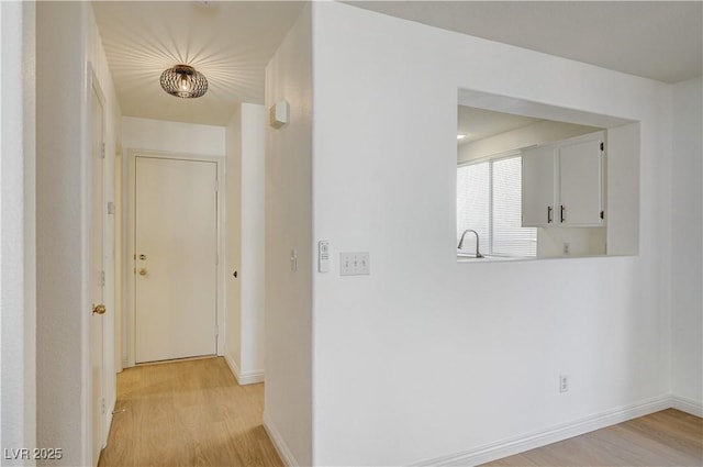 hallway featuring sink and light hardwood / wood-style flooring