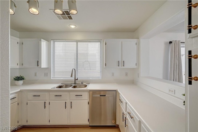 kitchen with stainless steel dishwasher, sink, light hardwood / wood-style flooring, and white cabinets