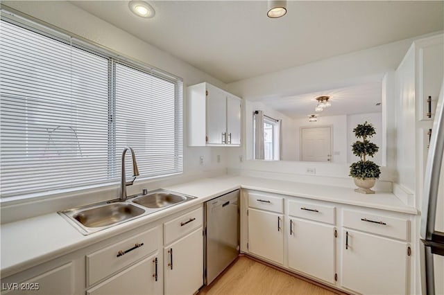 kitchen with sink, light hardwood / wood-style flooring, white cabinets, and dishwasher