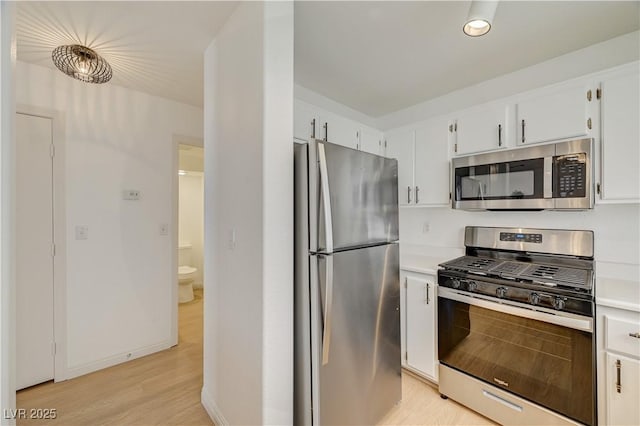 kitchen featuring white cabinetry, light wood-type flooring, and appliances with stainless steel finishes