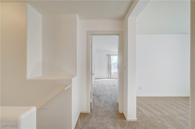 hallway featuring light colored carpet