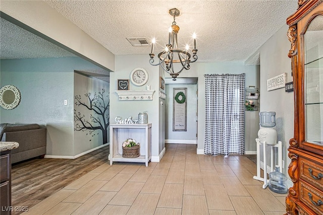 foyer with an inviting chandelier and a textured ceiling