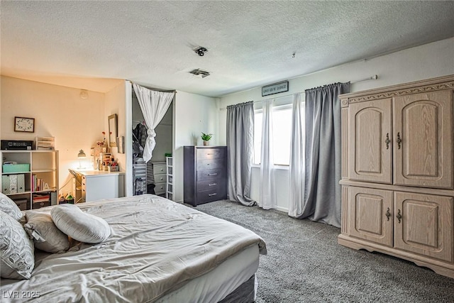 bedroom with light colored carpet and a textured ceiling