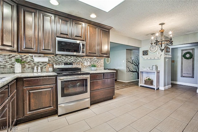 kitchen featuring appliances with stainless steel finishes, dark brown cabinetry, and decorative backsplash