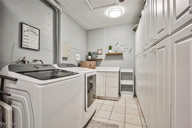 washroom with independent washer and dryer, cabinets, and light tile patterned floors