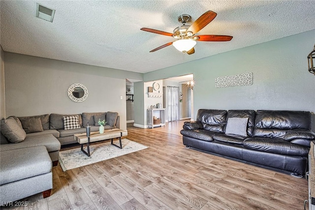 living room featuring hardwood / wood-style floors, a textured ceiling, and ceiling fan