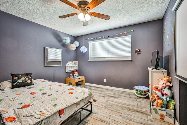 bedroom with wood-type flooring, ceiling fan, and a textured ceiling