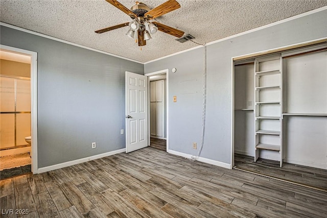 unfurnished bedroom featuring hardwood / wood-style flooring, a closet, ornamental molding, and a textured ceiling