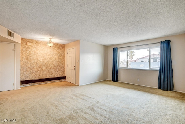 unfurnished room featuring light carpet and a textured ceiling