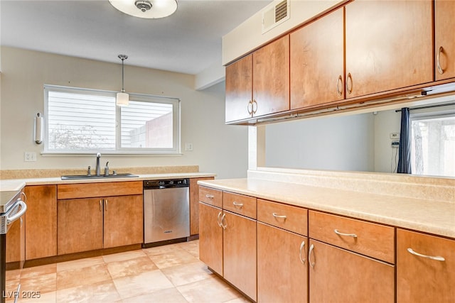 kitchen with appliances with stainless steel finishes, decorative light fixtures, and sink