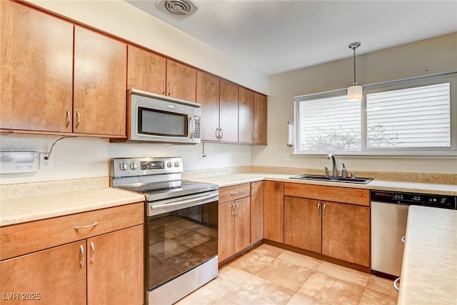 kitchen featuring stainless steel appliances, sink, and pendant lighting