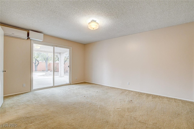 carpeted spare room featuring a wall unit AC and a textured ceiling