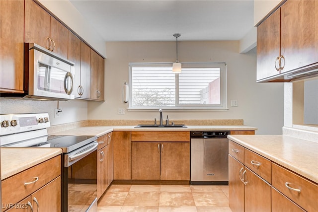 kitchen with sink, decorative light fixtures, and appliances with stainless steel finishes