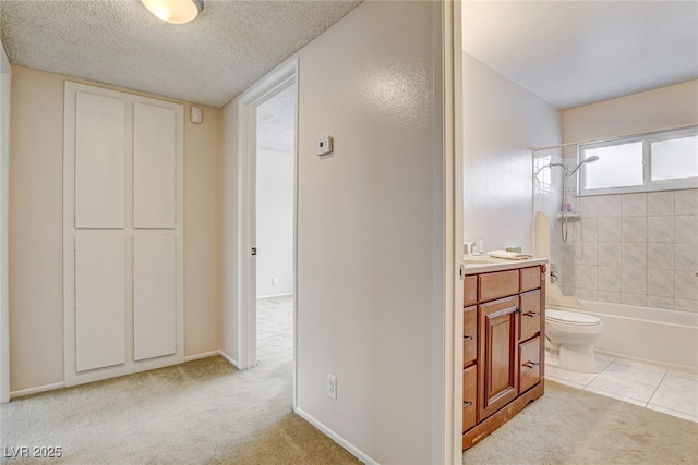 full bathroom featuring toilet, a textured ceiling, vanity, tiled shower / bath combo, and tile patterned flooring