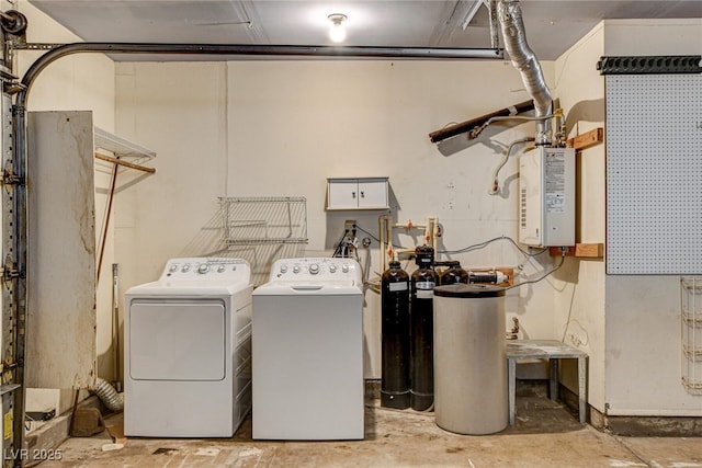 clothes washing area featuring water heater and washer and dryer