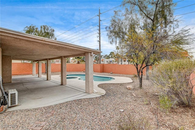 view of swimming pool with ac unit and a patio