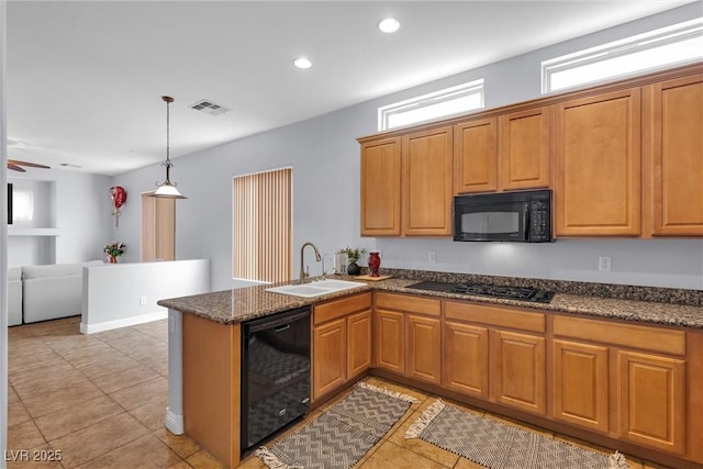 kitchen with a wealth of natural light, kitchen peninsula, sink, and black appliances