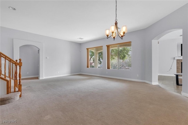 unfurnished living room with a chandelier and light carpet