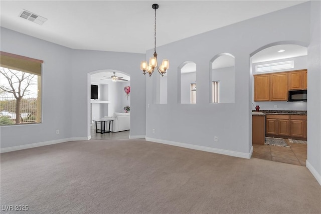 interior space featuring light carpet and ceiling fan with notable chandelier