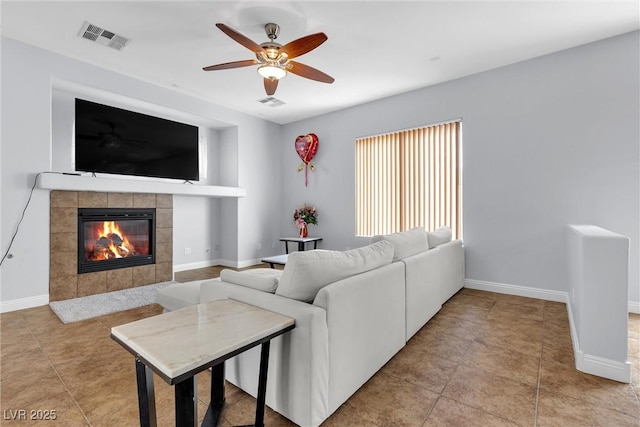 tiled living room featuring ceiling fan and a fireplace