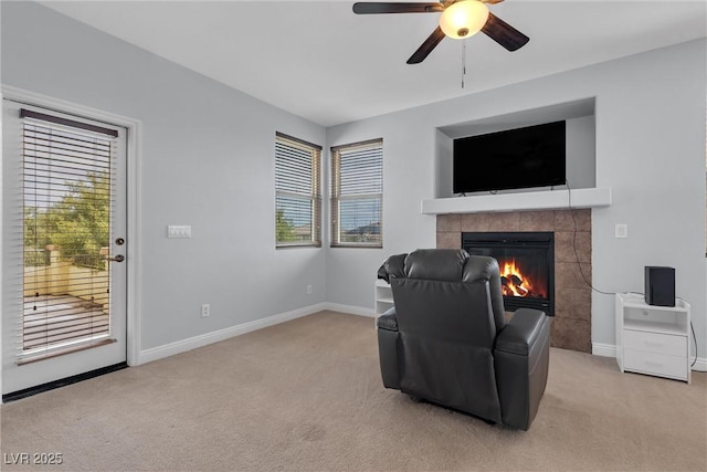 sitting room with a tile fireplace, a wealth of natural light, light carpet, and ceiling fan