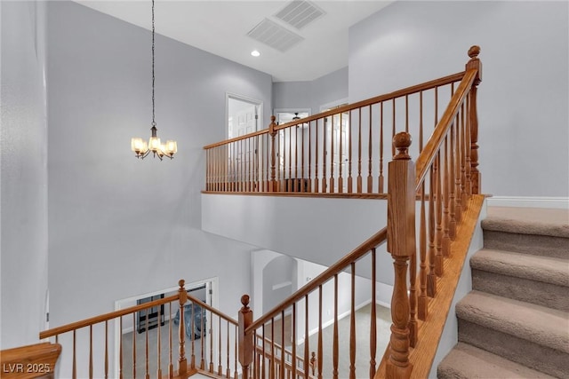 staircase featuring a notable chandelier