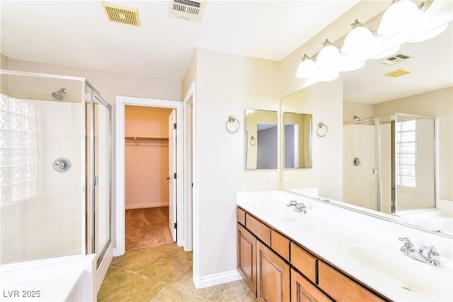 bathroom with walk in shower, vanity, and tile patterned flooring