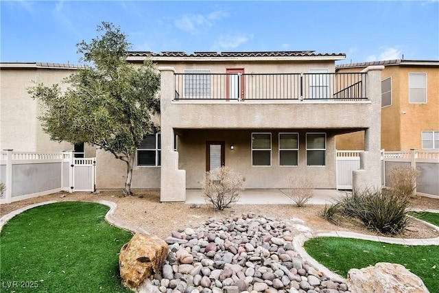 back of property featuring a balcony and a patio area